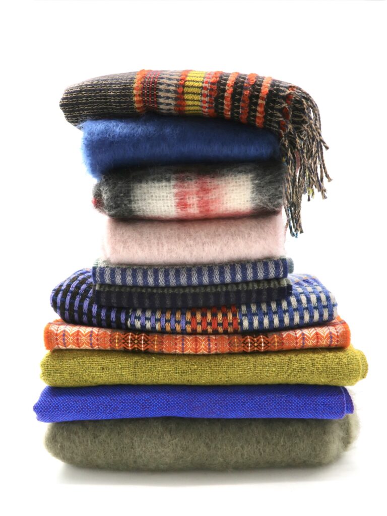 Stapel aus feinen Schals und Stolen aus Wolle und Seide.