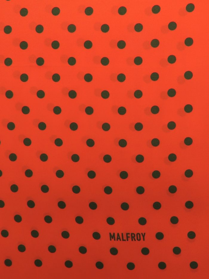 Polkadots in dunkelgrün auf orangerotem Grund